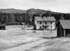 Mang�rdsbyggnaden fr�n nordv�st med lillstugan till h�ger. Vackra bj�rkar kantar �lven.