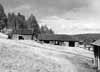 Vedbod samt s�dra delen av vinkelbyggnad, som inrymmer loge och ladug�rd. I bakgrunden skymtar man den s.k. r�kstugan.