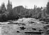 Samma sidogren i nerstr�msriktningen sedd fr�n huvudf�ran. Uppe p� �lvbrinken ligger tulltj�nstem�nnens bostadshus.