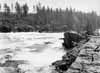 Fr�n ledvallen f�ngar vi denna bild av Sandk�llsforsens nedre del i riktning mot sydost. Vid h�gvattenf�ring ger �lven h�r ett m�ktigt intryck.